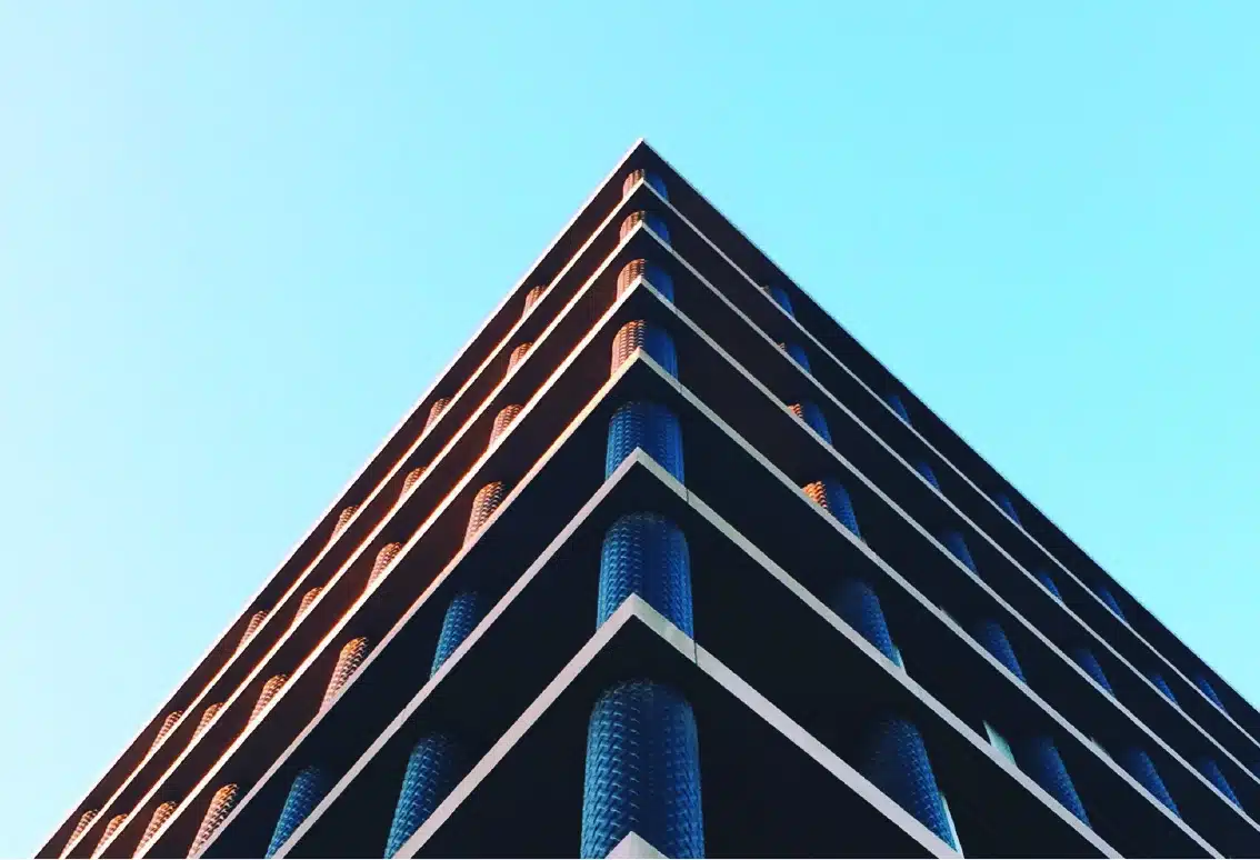 Edificio moderno visto dal basso contro il cielo: la competenza tecnica di PCQ nell&rsquo;ingegneria civile e impiantistica
